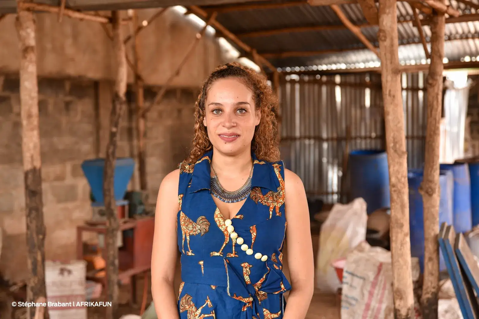 Portrait de Naomi Fagla Medegan dans son atelier, devant des installations de production