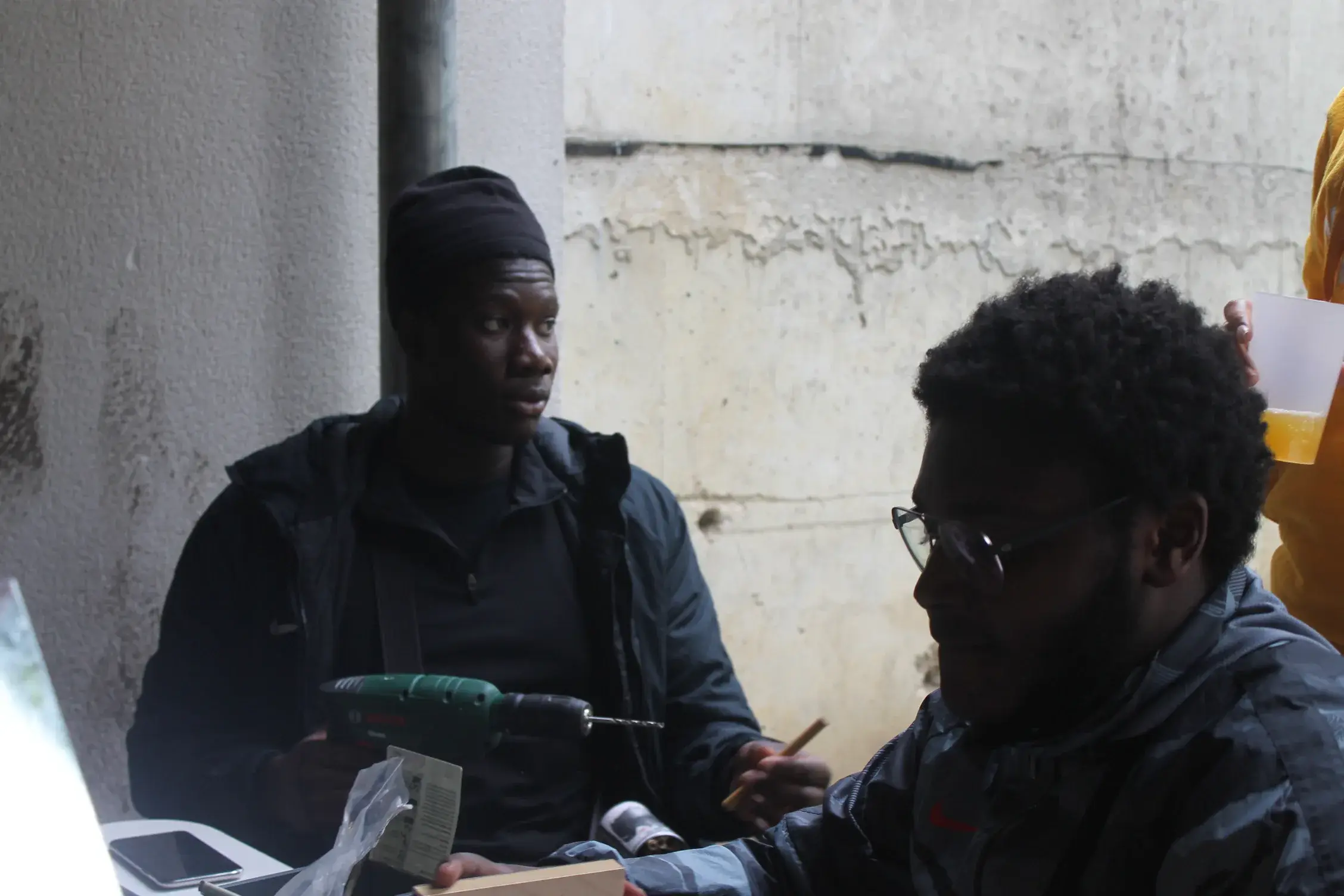 Deux hommes installés à une table dans un local, l’un explique en désignant un document.