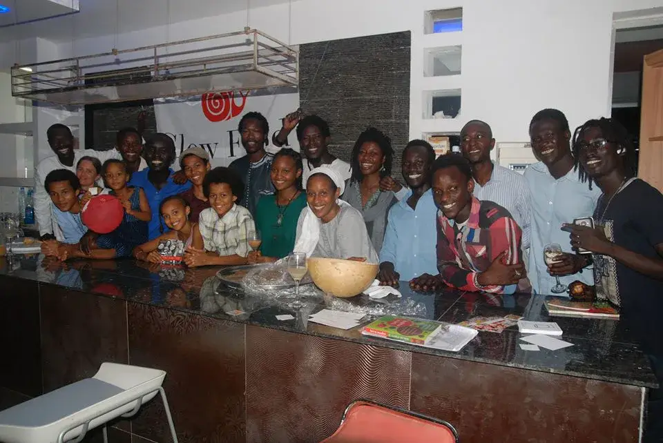 Groupe de jeunes et d’adultes réunis autour d’un buffet lors d’un événement Slow Food