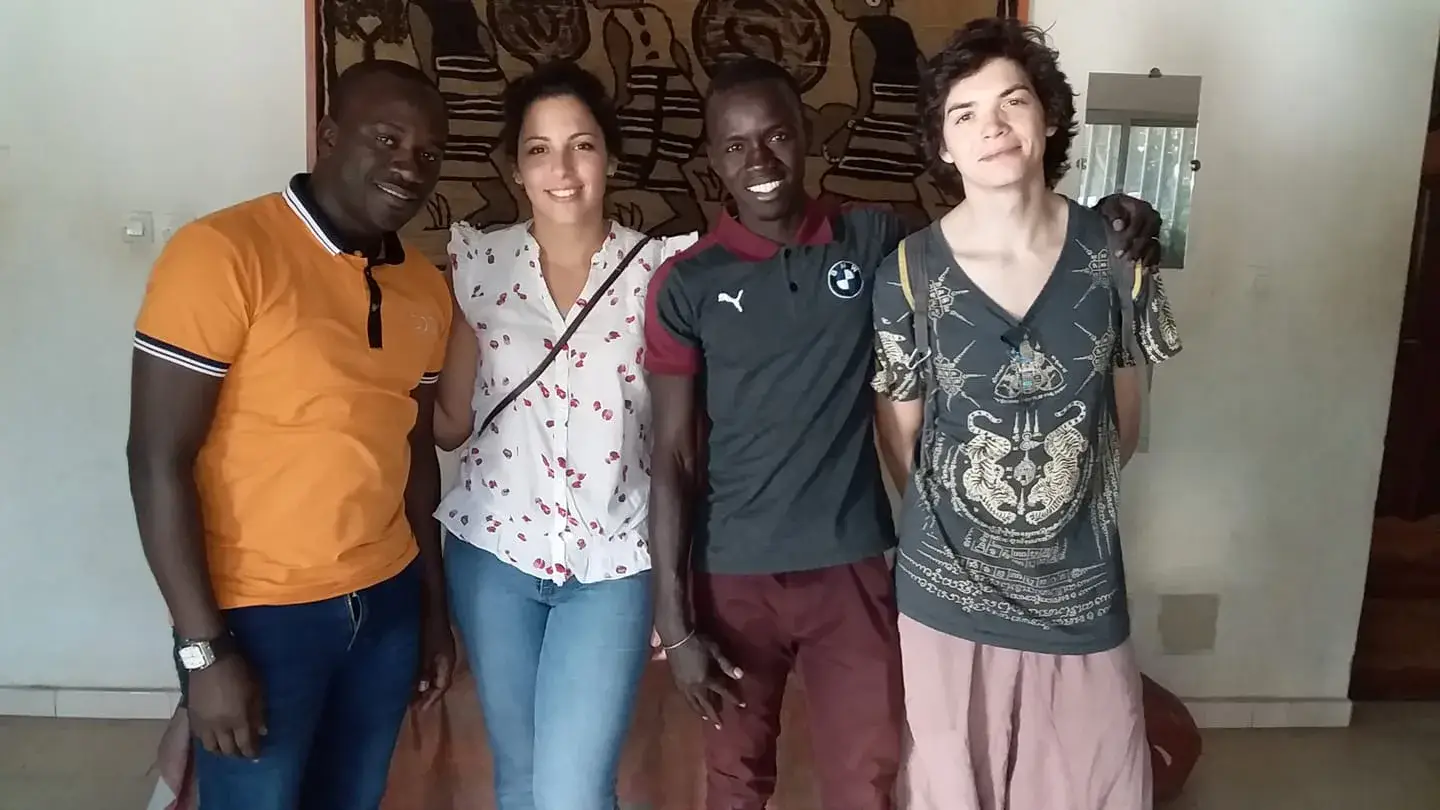 Quatre personnes posent devant une tenture lors d’une rencontre au Sénégal.