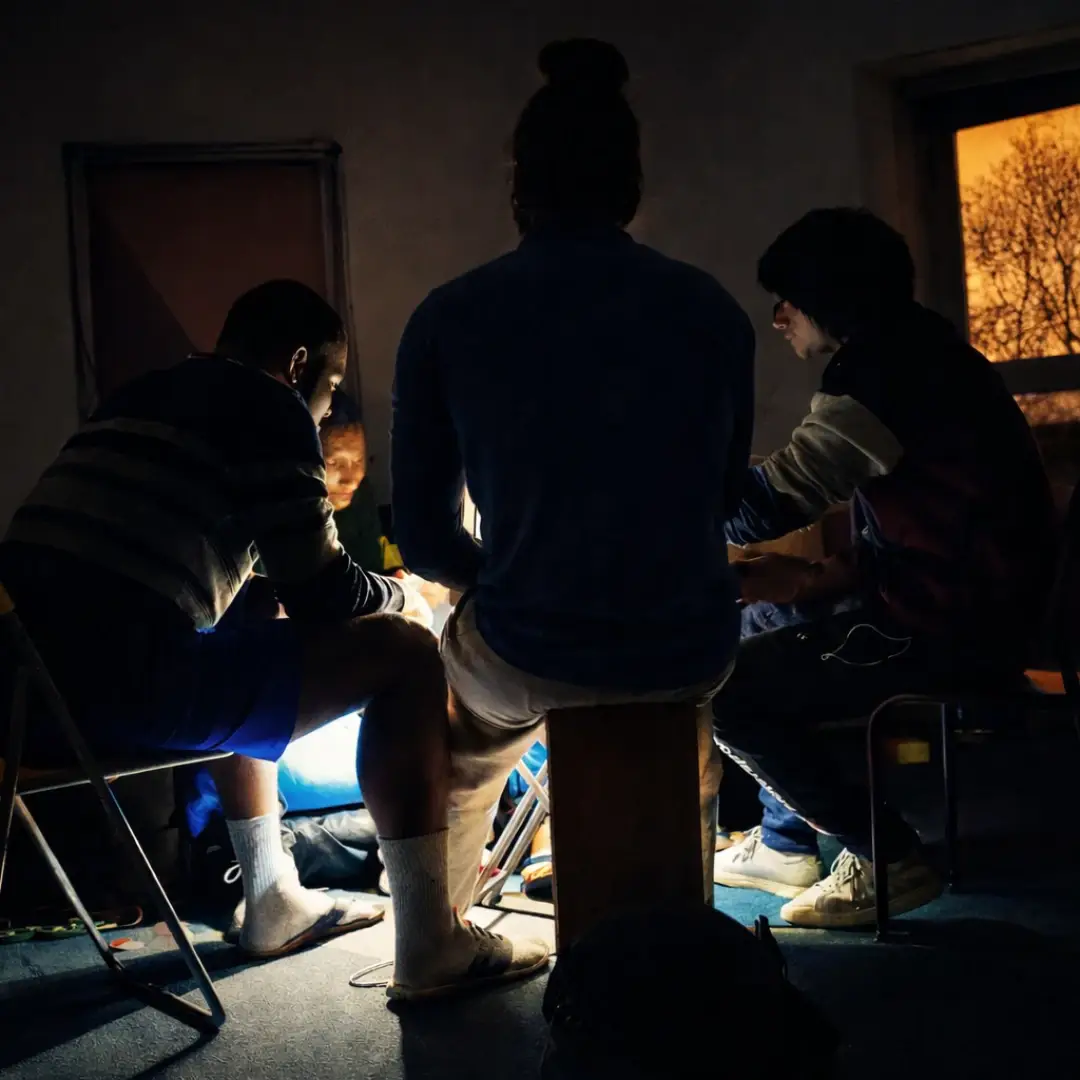 Trois jeunes réunis autour d’une lumière lors d’un atelier