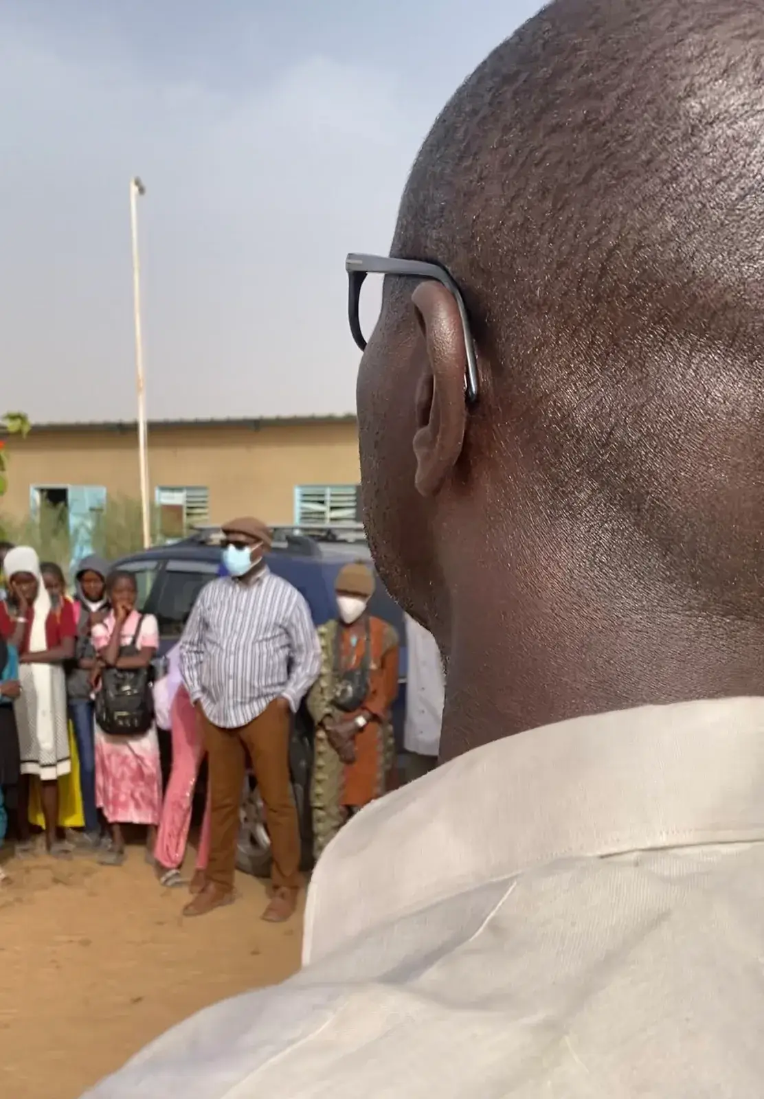 Un enseignant observe un groupe d’élèves dans la cour d’un établissement