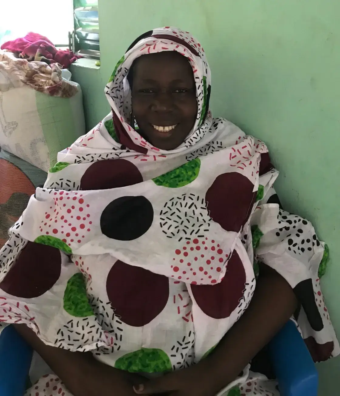 Portrait d’une femme souriante portant un pagne à motifs