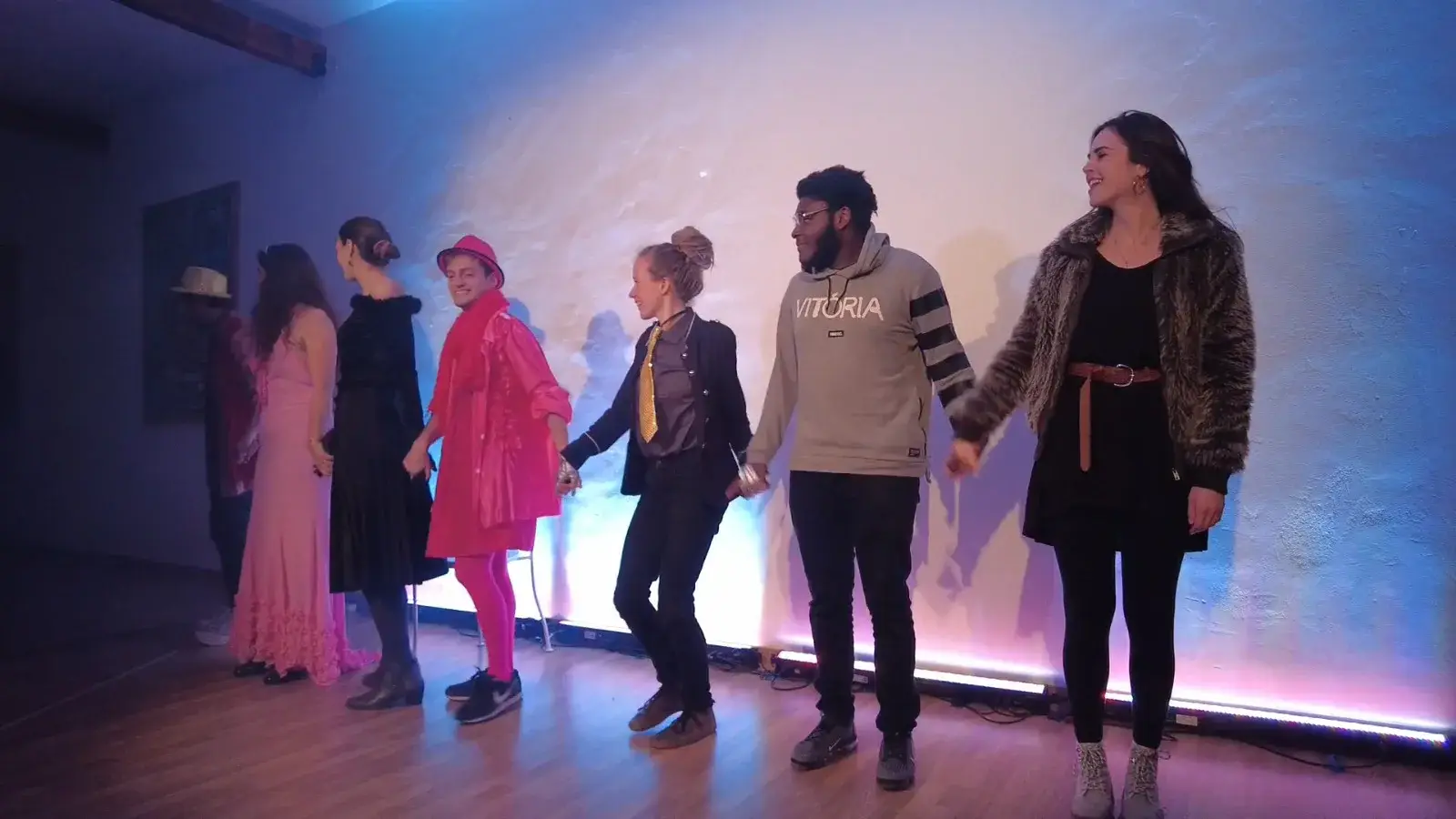 Les jeunes comédiens se tiennent par la main sur scène devant un écran bleu.