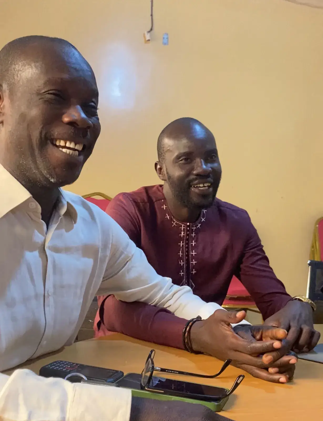 Deux hommes souriant lors d’un entretien à une table