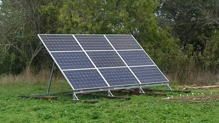 Un panneau solaire installé sur une parcelle herbeuse.