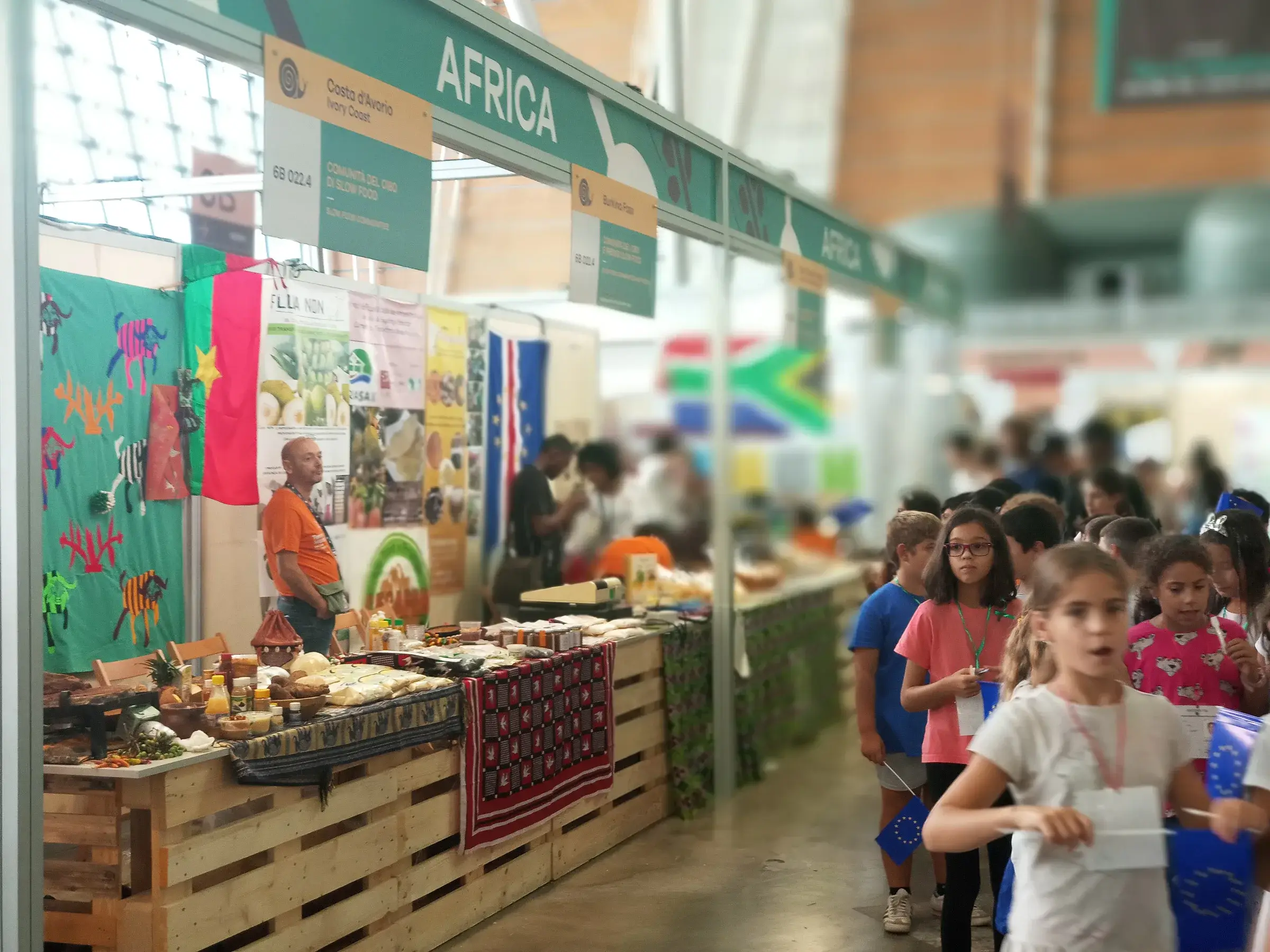 Allée du marché Africa avec des étals colorés et des visiteurs.