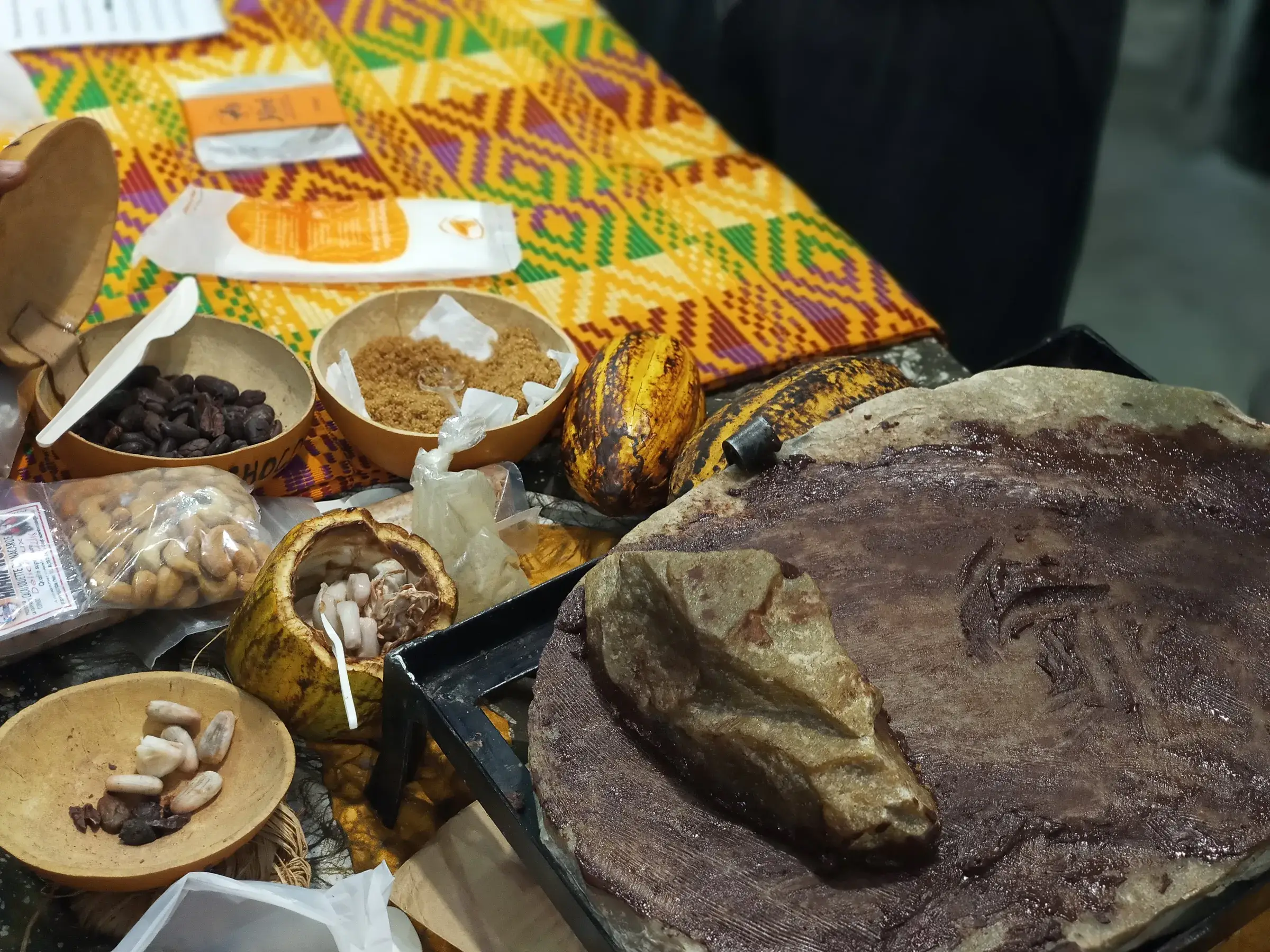 Table dressée de tissus colorés, de bols et d’une grande galette.