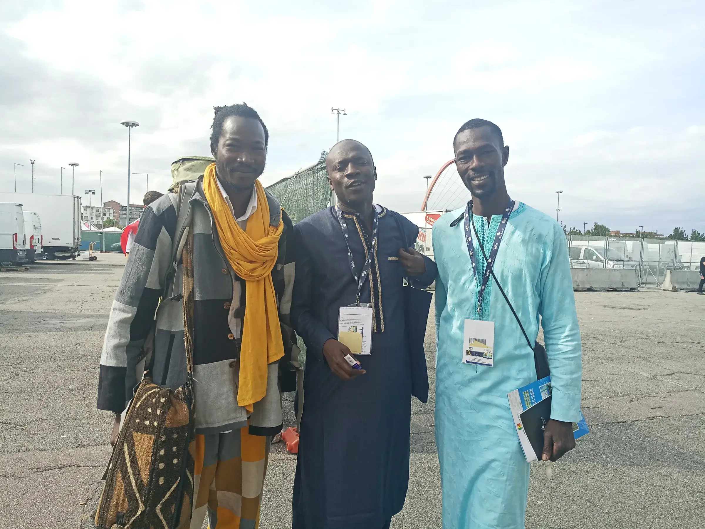 Quatre personnes prennent la pose devant un hall d’exposition.