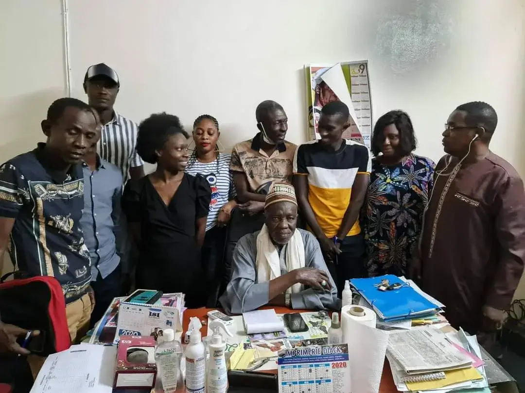 Groupe réuni autour d’une table couverte de matériel de santé, dans une salle
