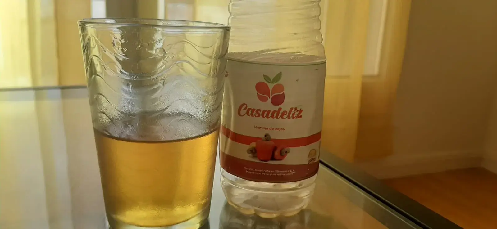 Jus de pomme de cajou Casadeliz dans une bouteille et un verre.