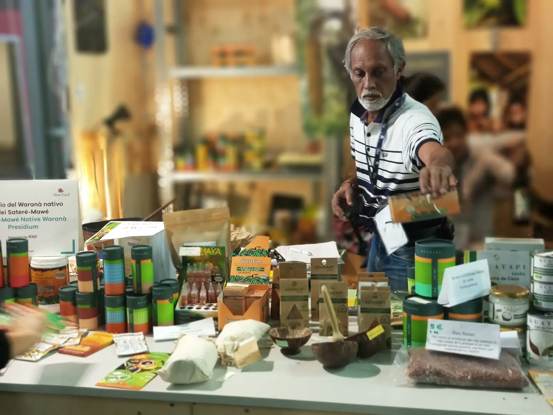 Un exposant présente des bocaux et des produits artisanaux sur son stand au salon Terra Madre.